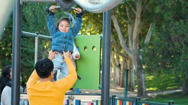 Hispanic family with two children playing zip line in a playground. Latin family.