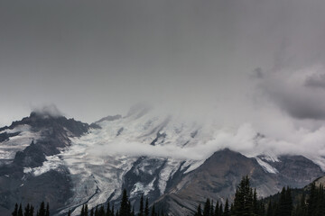 Mount Rainier east flank disappearing into the clouds on cold stormy September day first day of Fall, Mount Rainier National Park, Washington, United States