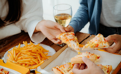 Hands taking slices of pizza close view. Group of Friends eating pizza at the beach. Fast food concept. Picnic at the beach. Summer vacation, holidays, travel, lifestyle and people concept.