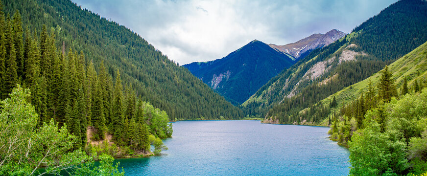 Lake Kaindy sunken forest in Kazakhstan. Beautiful mountain nature landscape. Blue lake Kolsai top view. Panoramic view of the nature reserve.