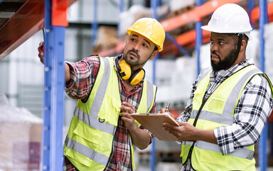 Two diverse professional male workers holding board, checking shipping stocks in storage, warehouse...