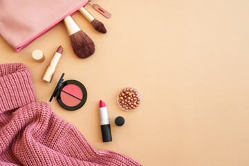 Cloth and accessories on color background. Sweater, cosmetic bag and make-up products. Flat lay...