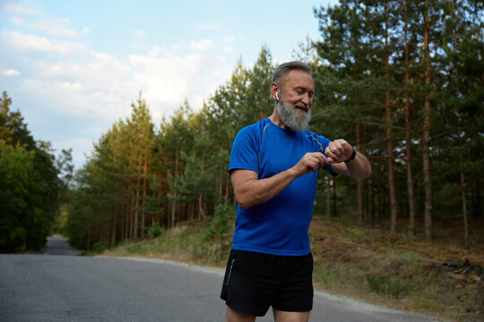 Retired sportsman using modern digital gadget during running - Powered by Adobe