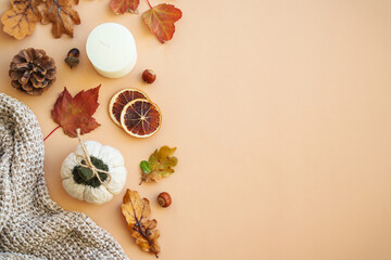 Autumn flat lay background. Warm knitted sweater, leaves, spices and home decor.