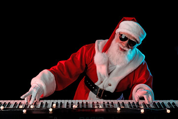 Santa Claus playing the electric piano in a nightclub at a Christmas and New Year party or...