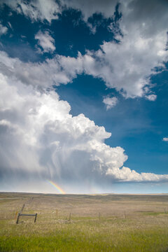 Huge thunderhead dumping rain and hail on the prairie of Southeast Wyoming providing a wonderful rainbow for those on this side of the storm; Chugwater, Wyoming, United States of America