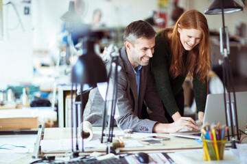 Two diverse colleagues working on a project together in a modern office
