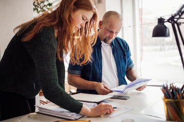 Young man and woman working together on a project in a startup company office