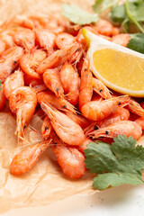 Shrimp with lemon and cilantro on a light background.