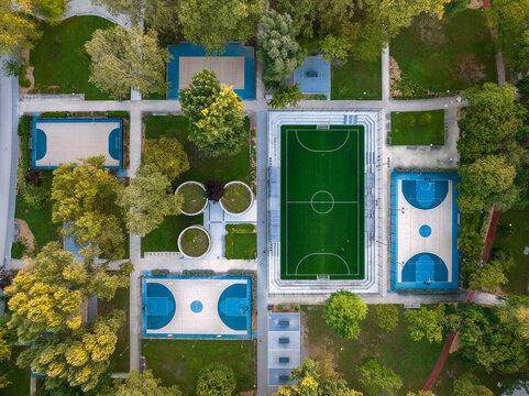 Sport courts at a park in aerial view. Aerial photo about foutball, basketball courts and ping pong tables. Birds eye view about a Recreation park.