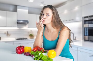 Obraz na płótnie Canvas Happy young woman eats fresh vegetables
