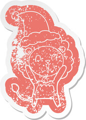 laughing lion quirky cartoon distressed sticker of a wearing santa hat