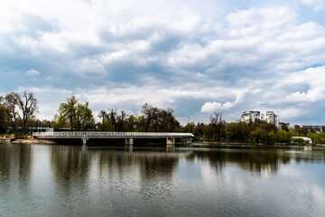 Obraz premium Pedestrian bridge in Bordei park over the lake. Bucharest, Romania.