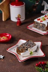 Dessert, Polish poppy seed cake with apples and candied fruits, covered with sugar icing, in Christmas style on a brown concrete background. Merry Christmas. Polish cuisine