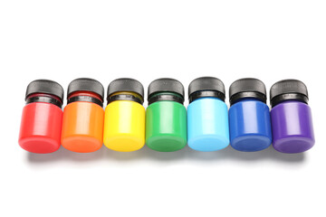 Jars with colorful gouache on white background