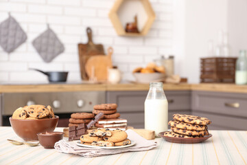 Obraz na płótnie Canvas Cookies with chocolate and bottle of milk on table in kitchen