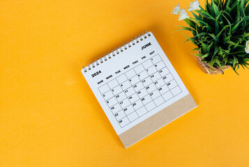 June 2024 desk calendar on yellow background. Directly above. Flat lay.