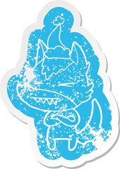 angry wolf quirky cartoon distressed sticker of a wearing santa hat