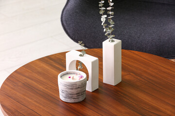 Holder with candle and decor on table in room