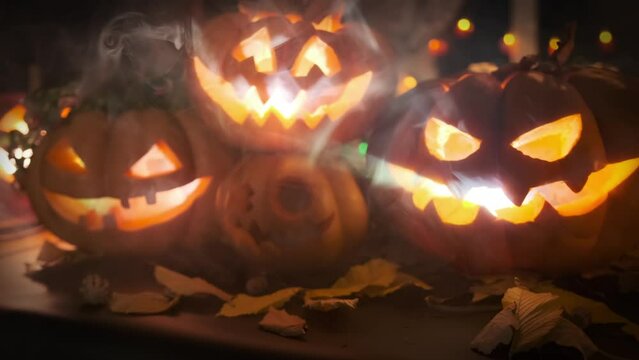 In foggy smoke Jack O Lanterns glowing with light from within scary Halloween festive background party invitation autumn decoration neon color lights and flickering garlands.