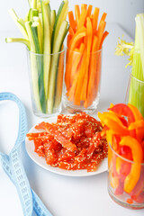 glass with juice, cut vegetables into strips, diet food, snacks on a plate, dried pieces of...