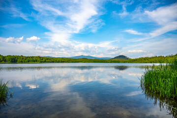 Landscape with Jested Mountain ridge reflected in water of Hamr Lake, or Hamr Pond. Czech Republic