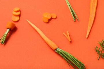 Fresh carrot and slices on orange background