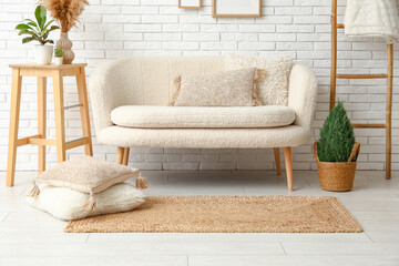 Interior of light living room with white sofa and wicker carpet