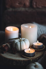 Autumn home composition with aromatic candle, dry citrus, cinnamon, anise. Aromatherapy on a grey fall morning, atmosphere of cosiness and relax. Wooden background close up copy space