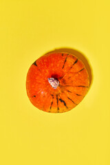 Top view image of pumpkin on yellow background. Autumn taste. Concept of vegetables, garden, harvesting, organic food, farmer market, heathy food. Copy space for ad