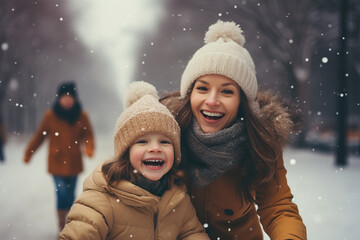 Happy mom and kid playing in winter park, enjoying snowy weather