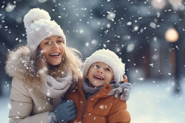 Obraz premium Happy mom and kid playing in winter park, enjoying snowy weather