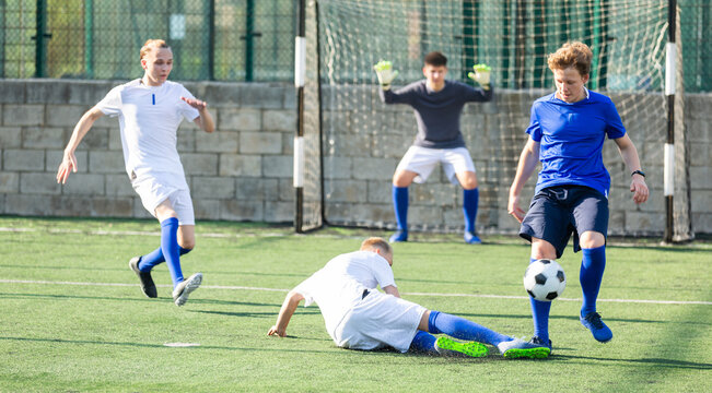 Junior football teams having scrimmage and struggling for ball
