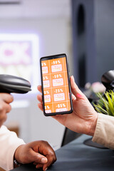 Mobile coupon marketing in fashion retail business. Customer showing smartphone with digital Black...