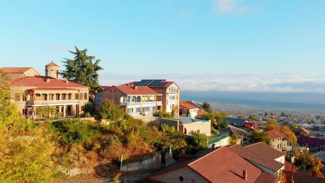 Aerial panning view Telavi town panorama with traditional georgian house buildings and alazani valley and caucasus mountains background