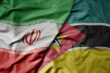 big waving realistic national colorful flag of iran and national flag of mozambique .