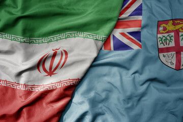 big waving realistic national colorful flag of iran and national flag of Fiji .