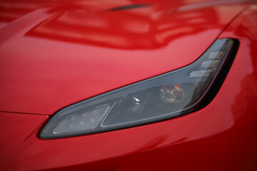 Fototapeta premium Close-up of the headlight of a red sports car.