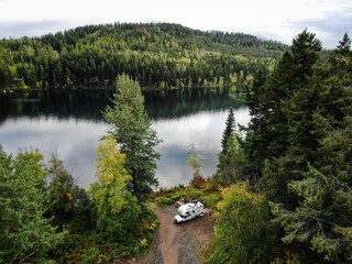 Aerial of truck camper camped on alpine lake in British Columbia