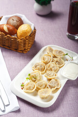 Meat dumplings with sour cream and parsley on a plate