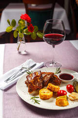 baked ribs with vegetables and sauce on a table in a restaurant