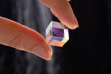 Optical glass cube in hand  Light dispersion,spectrum. Physics optics ray refractions