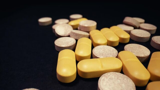 Drug pills spinning on a black tray