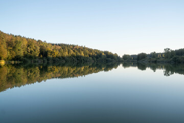 Fototapeta na wymiar Perfect reflection of trees in a calm lake