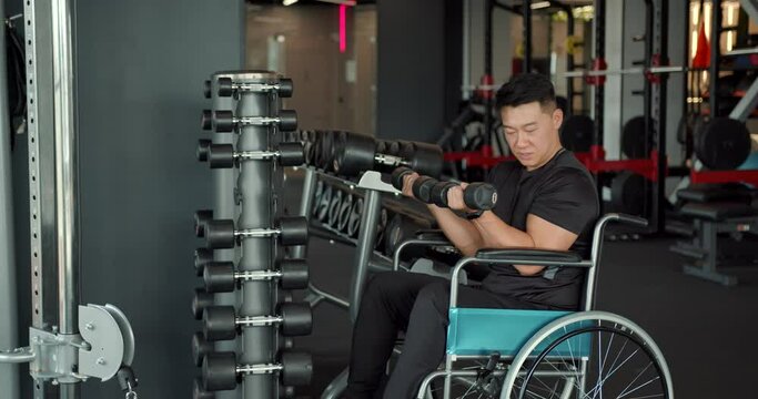 A disabled man in a wheelchair training in the gym