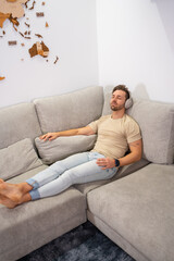 Man relaxed on the sofa listening to music