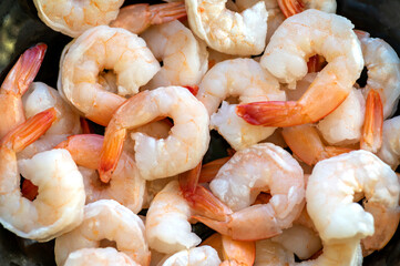 Many uncooked fresh prawns on the black color pan.