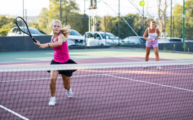 Obraz premium Sporty woman plays tennis. View through tennis net