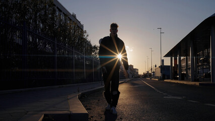 Dancing man in the street with sunset behind. Action. Young man dancing alone outdoors.
