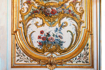 Antique decoration on the wall of a medieval house in France, with painted flowers and arabesques 